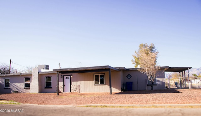 single story home featuring a carport and fence