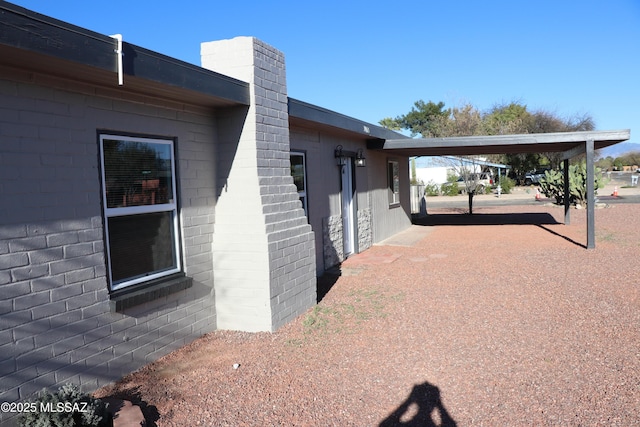 view of side of property featuring concrete block siding and a chimney