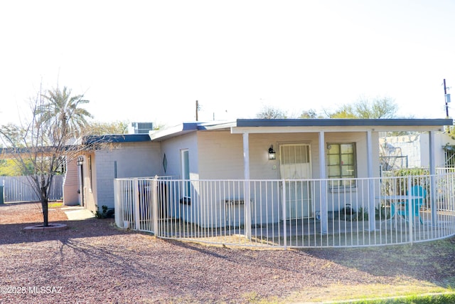 view of front of house with concrete block siding and fence