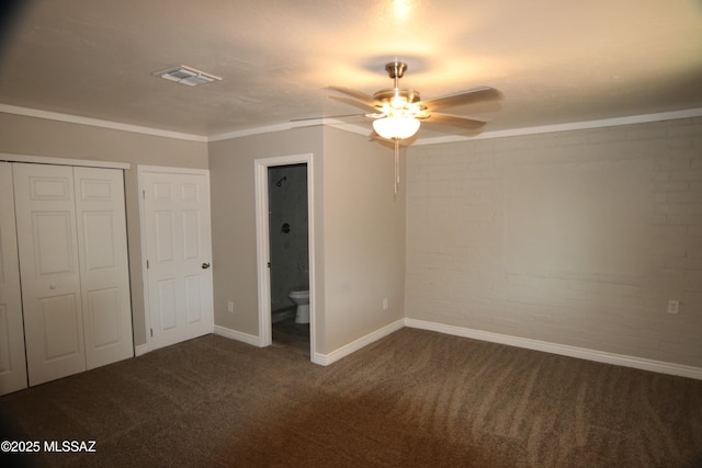 unfurnished bedroom with visible vents, brick wall, ensuite bath, a closet, and carpet flooring