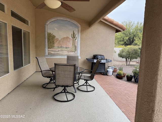 view of patio featuring outdoor dining area, a grill, and a ceiling fan