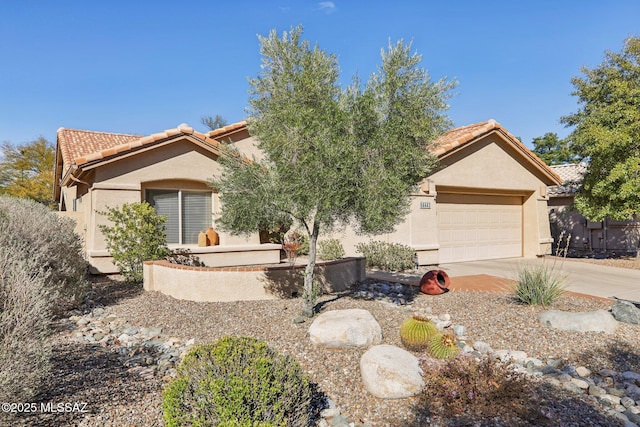 view of front of property featuring driveway, an attached garage, a tile roof, and stucco siding