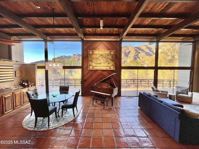 sunroom featuring beamed ceiling, an inviting chandelier, and wooden ceiling