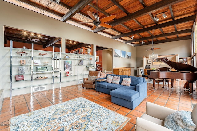 tiled living area featuring ceiling fan, visible vents, beam ceiling, and wooden ceiling