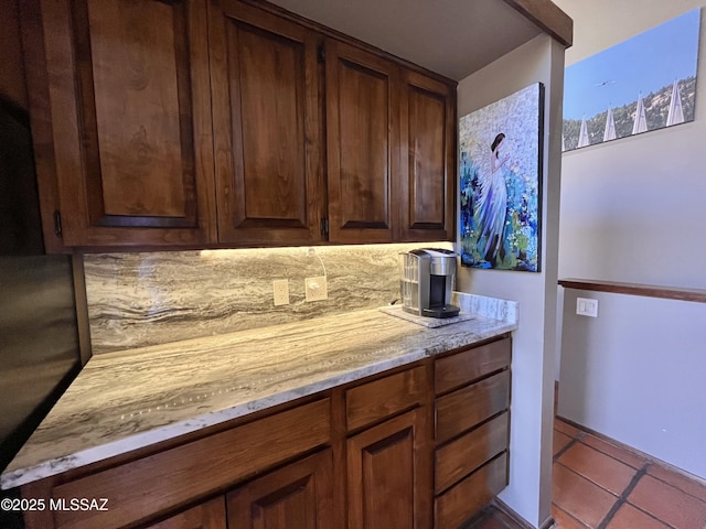 kitchen with light stone countertops, tasteful backsplash, and tile patterned flooring