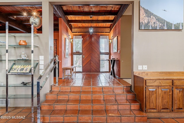 tiled entrance foyer featuring wooden walls, beamed ceiling, a mountain view, and visible vents