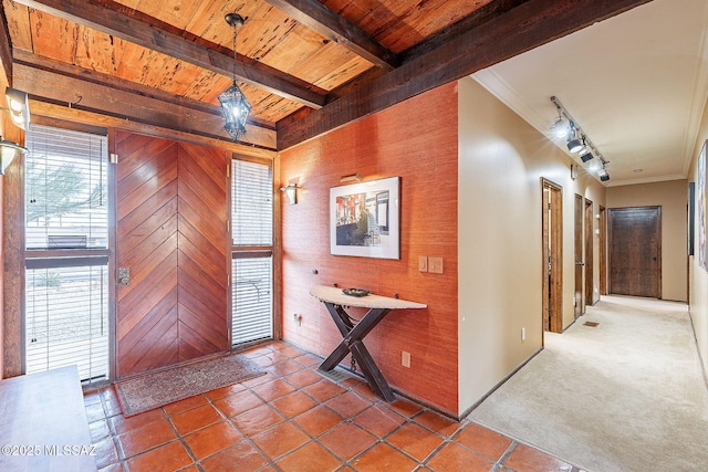 foyer entrance with beamed ceiling, wood ceiling, track lighting, and crown molding