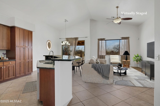 kitchen with hanging light fixtures, light tile patterned floors, brown cabinetry, and a sink