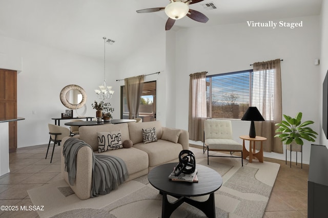 living area featuring light tile patterned floors, high vaulted ceiling, and visible vents