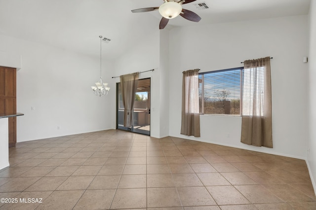 empty room featuring high vaulted ceiling, ceiling fan with notable chandelier, visible vents, and light tile patterned floors