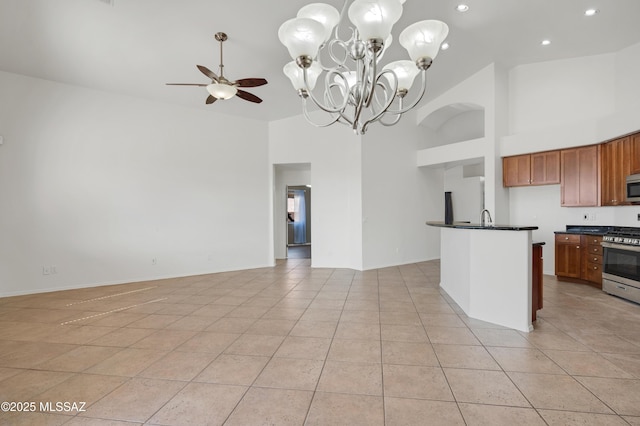 kitchen featuring dark countertops, stainless steel appliances, brown cabinets, and open floor plan