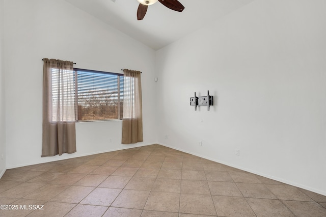 spare room featuring ceiling fan, vaulted ceiling, baseboards, and light tile patterned floors