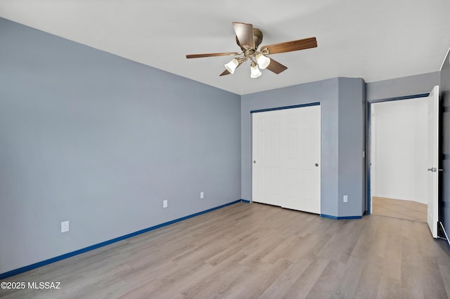 unfurnished bedroom featuring baseboards, ceiling fan, a closet, and light wood-style floors