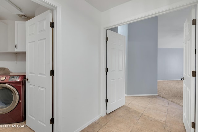 laundry area with light carpet, visible vents, baseboards, cabinet space, and washer / dryer