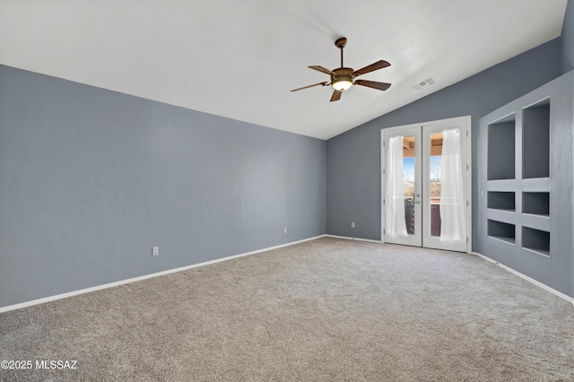 spare room with french doors, visible vents, a ceiling fan, carpet flooring, and vaulted ceiling