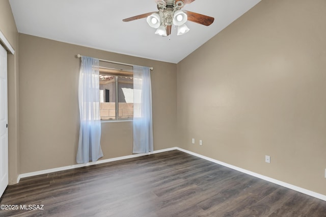 spare room with lofted ceiling, ceiling fan, baseboards, and dark wood-style flooring