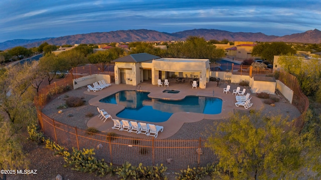 community pool featuring a patio, fence, and a mountain view