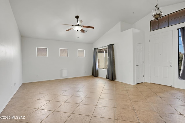 interior space featuring lofted ceiling, light tile patterned floors, baseboards, and ceiling fan with notable chandelier