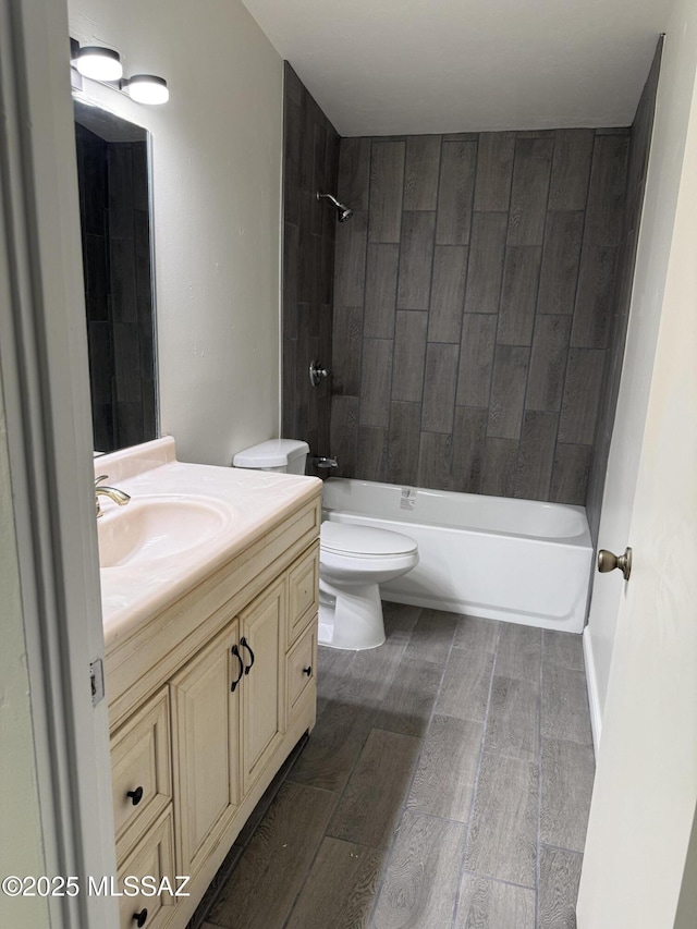 bathroom featuring wood finish floors, bathtub / shower combination, vanity, and toilet