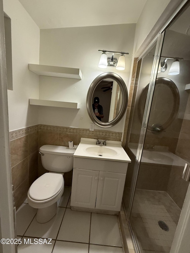 full bath with toilet, tile patterned flooring, vanity, a shower stall, and tile walls