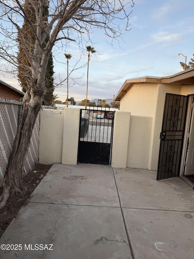 view of gate featuring a patio area and a fenced backyard