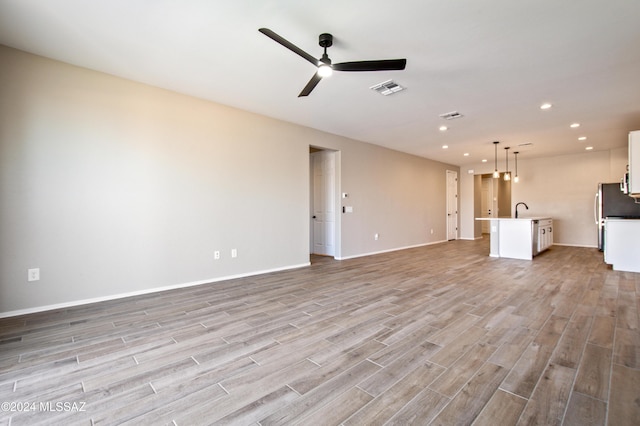 unfurnished living room with light wood finished floors, visible vents, baseboards, ceiling fan, and recessed lighting