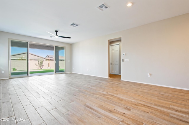 unfurnished room with ceiling fan, light wood-type flooring, visible vents, and baseboards