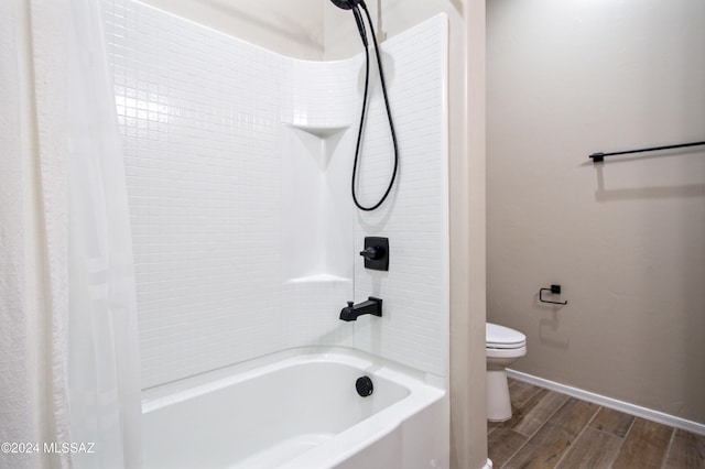 full bath with shower / tub combo, baseboards, toilet, and wood finished floors