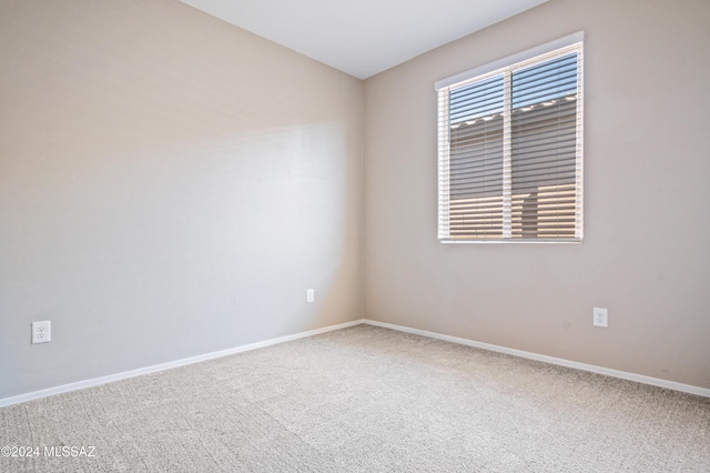 unfurnished room featuring carpet floors and baseboards