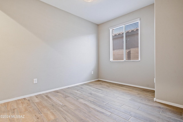 empty room with baseboards and light wood-style floors