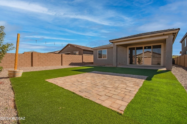 back of house featuring a patio, a yard, a fenced backyard, and stucco siding