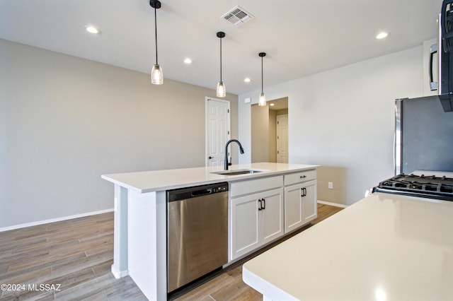 kitchen with a kitchen island with sink, white cabinets, light countertops, dishwasher, and decorative light fixtures