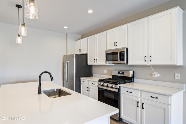 kitchen with light countertops, appliances with stainless steel finishes, a sink, and pendant lighting