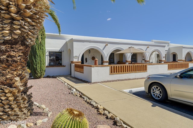 view of front facade with a fenced front yard, uncovered parking, and stucco siding