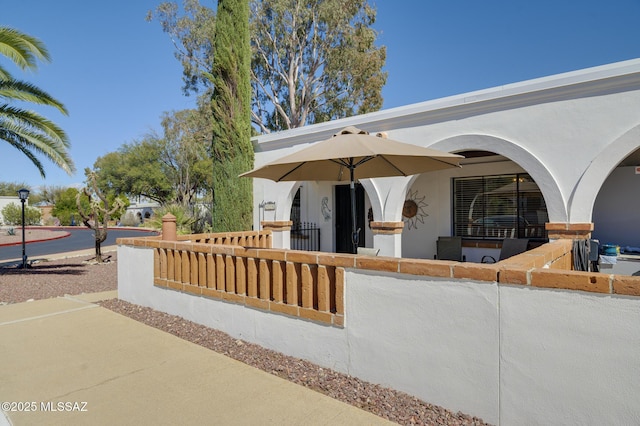 exterior space featuring a fenced front yard and stucco siding