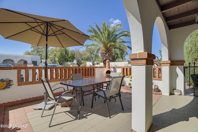 view of patio featuring outdoor dining area and fence