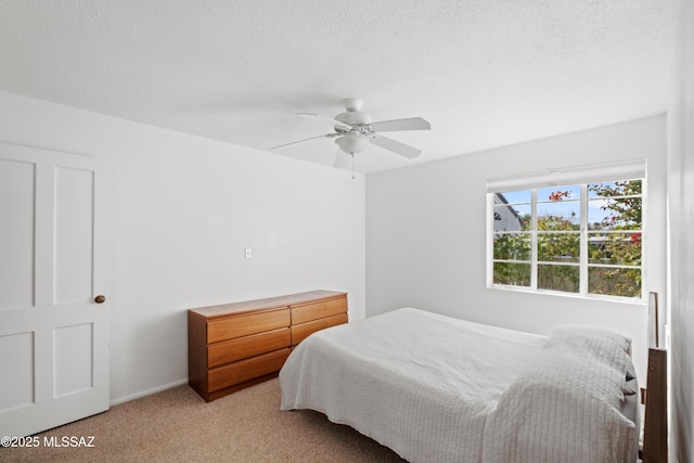 carpeted bedroom with a textured ceiling and a ceiling fan