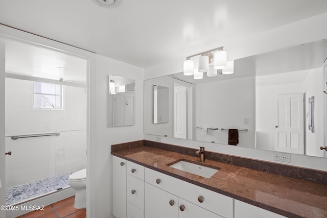 bathroom with toilet, a shower stall, tile patterned flooring, and vanity