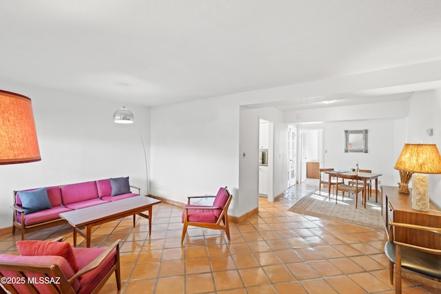 living area with light tile patterned floors and baseboards