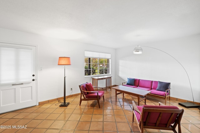 living area featuring light tile patterned floors and baseboards