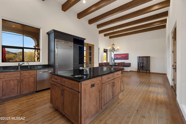 kitchen featuring light wood-type flooring, stainless steel appliances, a sink, and a center island