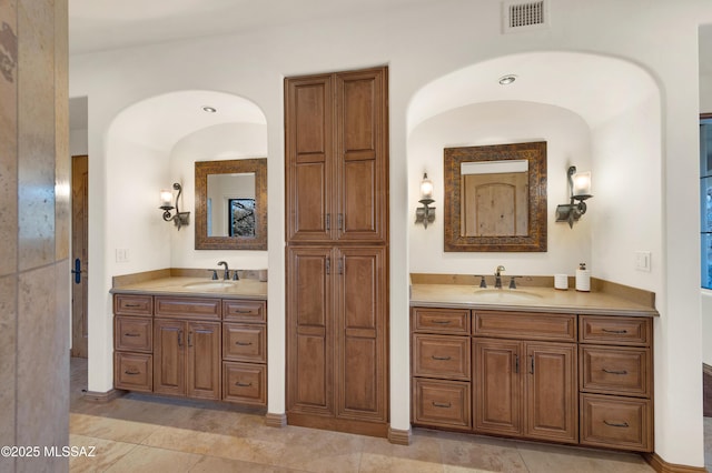 bathroom featuring two vanities, visible vents, and a sink