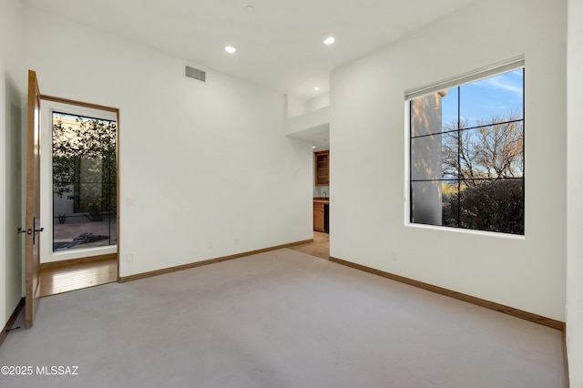 spare room featuring baseboards, recessed lighting, visible vents, and light colored carpet