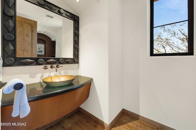 bathroom with baseboards, visible vents, wood finished floors, and vanity