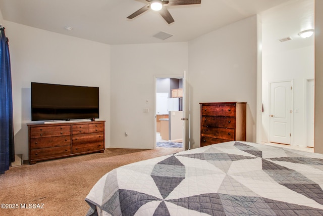 bedroom featuring carpet, visible vents, ensuite bathroom, and freestanding refrigerator