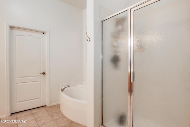 bathroom with a stall shower, tile patterned flooring, and a bath