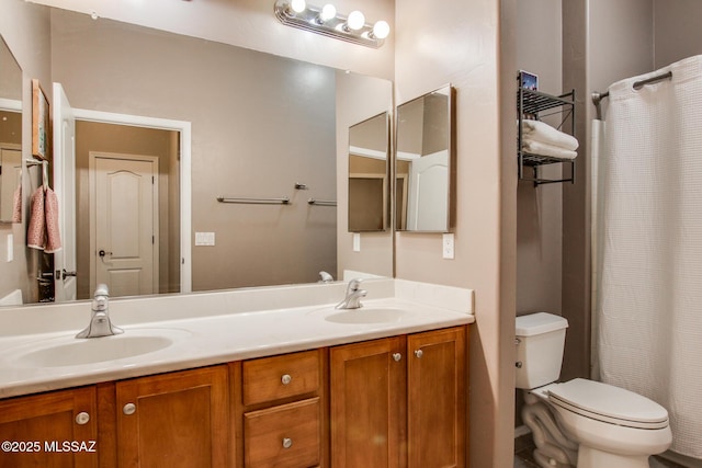 bathroom with toilet, a shower with curtain, double vanity, and a sink