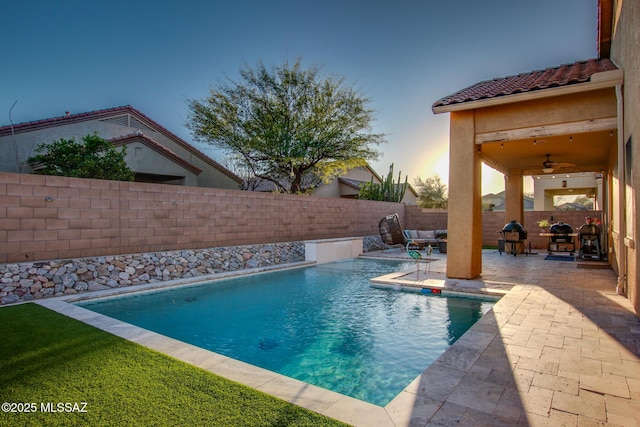 view of swimming pool with a fenced in pool, a fenced backyard, a patio, and a ceiling fan