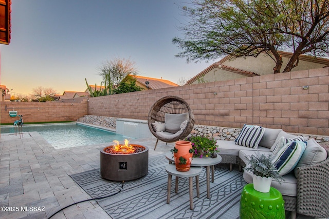 view of swimming pool featuring an outdoor living space with a fire pit, a patio area, and a fenced backyard