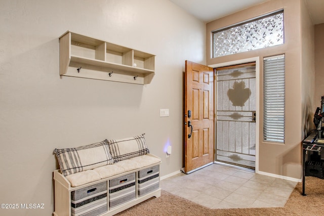 mudroom with light tile patterned flooring, baseboards, and light colored carpet